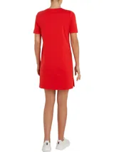 Vestido rojo de algodón con cuello redondo y mangas cortas. Presenta un logo de Tommy Hilfiger bordado en blanco en el pecho y la bandera de la marca bordada en la manga.