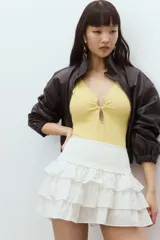 Minifalda blanca con lunares dorados, cintura elastizada y tres niveles de volados.