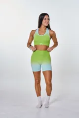 Conjunto deportivo de top y short con degradé de verde lima a celeste. El top es de espalda deportiva con logo "bk." en el frente. El short es tiro alto.