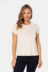 Remera color beige con estampado de aves en tonos celeste, lila y dorado.