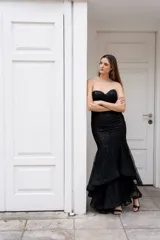 Vestido largo de fiesta color negro con lentejuelas, corte sirena, strapless con escote corazón y falda con volados.