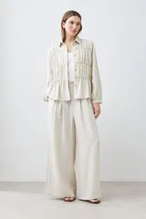 Pantalón palazzo color beige melange de tiro alto con pinzas delanteras y corte amplio.