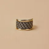 Anillo ancho de plata con diseño trenzado y bordes de oro.