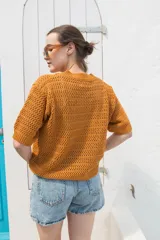 Saco tejido calado color celeste con mangas al codo y botones de coco.