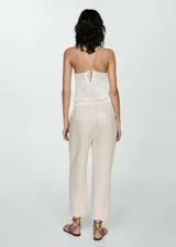 Pantalón negro de lino con diseño crop y jogger, tiro medio, cintura elástica con lazo, dos bolsillos laterales y dos bolsillos de ribete en la parte posterior.