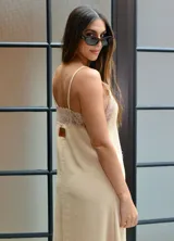 Vestido largo color beige con breteles finos y detalles de encaje en el escote.