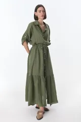 Vestido camisero largo color verde militar, con cuello camisero, mangas 3/4 con trabillas, cierre frontal con botones y lazo ajustable en la cintura.