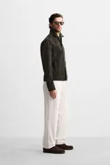 Pantalón de vestir color crema, de corte recto, con bolsillos laterales y traseros de ojal con botón.
