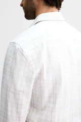 Camisa de vestir slim fit de algodón, color blanco con diseño de cuadros en tonos grises y beige. Tiene cuello italiano, mangas largas con puños abotonados y cierre frontal con botones.