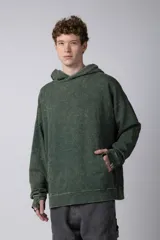 Buzo canguro verde con efecto desgastado, capucha con cordón ajustable, bolsillo frontal y puños con orificio para el pulgar.