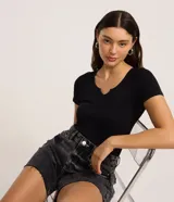 Body negro de poliamida seamless con textura acanalada, cuello en V, mangas cortas y cierre en la entrepierna.