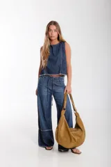 Cartera hobo grande de cuero descarne color marrón, con correa de hombro ajustable y cierre superior con cremallera.