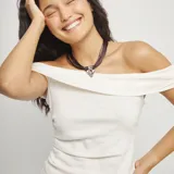 Collar tipo gargantilla con múltiples tiras de cordón de cuero marrón oscuro y un dije central de corazón plateado con acabado martillado.