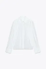 Camisa blanca de popelín con cuello solapa y manga larga.