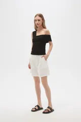 Bermuda blanca de viscosa con pinzas, corte holgado y tiro alto.