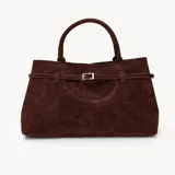 Bolso tote marrón de gamuza con doble asa corta y correa con hebilla decorativa.