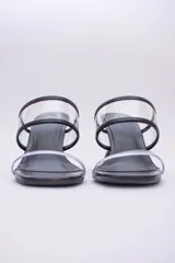 Sandalias plateadas con taco de forma geométrica y tiras transparentes.