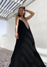 Vestido largo negro con escote en V y apliques de lentejuelas doradas en el corpiño.