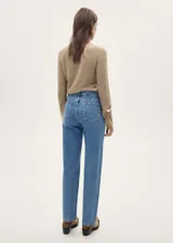 Pantalón de jean celeste de tiro medio, corte recto, cinco bolsillos y tachuelas decorativas.