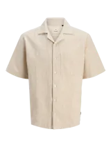 Camisa de manga corta color beige con cuello resort y cierre de botones. Confeccionada en tejido jacquard con mezcla de algodón y lino.