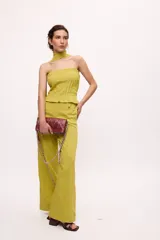 Pantalón recto color amarillo con rayas verticales blancas.