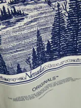 Camiseta gris claro de manga corta con cuello redondo y estampado en la espalda con un paisaje de montañas y el texto "Sierra Nevada Mountains".