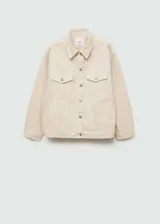 Chaqueta color crema estilo tejana vaquera, de corte oversize, con cuello camisero, cierre frontal de botones, mangas largas con puños abotonados, dos bolsillos de parche con solapa en el pecho y bolsillos laterales.