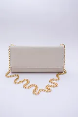 Cartera tipo sobre color beige con textura granulada y correa de cadena dorada.