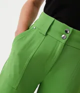Pantalón carrot verde manzana de poliéster, tiro alto, con bolsillos laterales y cierre frontal con doble botón.