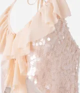 Blusa color rosa pálido con lentejuelas y volados, de escote halter y espalda descubierta.