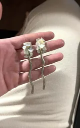 Aros colgantes con forma de rama de alpaca color plateado, con incrustaciones de nácar en forma de flor.