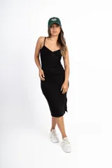 Vestido midi negro de punto canalé, con breteles finos, escote en V y dos botones decorativos.