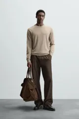 Jersey de hombre color beige claro, tejido en lana, de corte recto, cuello redondo y mangas largas con terminaciones en rib.