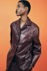 Cazadora de cuero color borgoña, con cuello solapa, manga larga, bolsillos de vivo en delantero y cierre frontal con botones.