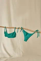 Conjunto de bikini con estampado animal print, compuesto por un corpiño bandeau con breteles finos y una bombacha vedetina con tiras laterales ajustables.