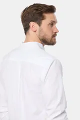 Camisa de lino color beige, de manga larga, cuello mao, medio abotonada y corte slim.