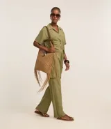 Pantalón largo color verde oliva, de malla orly, modelo pijama, con cintura elástica, lazo en la cintura y bolsillos cargo en los laterales.