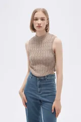 Chaleco verde pálido de punto con cuello alto y diseño trenzado.