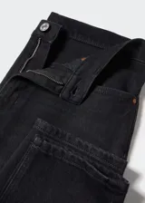 Jeans mom fit color negro con tiro alto, corte a la altura del tobillo y cinco bolsillos. Confeccionado en tejido de algodón elástico estilo tejano vaquero. Cierre de cremallera y botón.