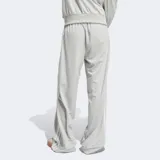 Pantalón deportivo Adidas Adicolor Classic Firebird color gris con tres rayas blancas a los costados.