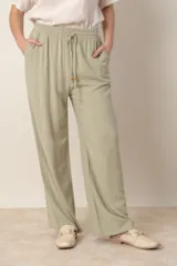 Pantalón ancho color beige de lino y rayón, con cintura elastizada ajustable con cordón y bolsillos laterales.