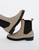 Bota Chelsea color crema de cuero vacuno, con elástico lateral negro, suela de cuero y taco de 2,5 cm. Hecha a mano en Argentina.