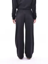 Pantalón de tejido de punto color bordó, de corte ancho y tiro alto con elástico y cordón ajustable en la cintura. Presenta costuras verticales marcadas en el frente de cada pierna.