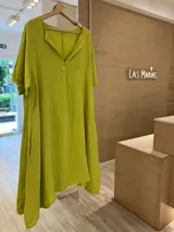 Vestido fucsia de lino estilo túnica, con escote en V, manga corta y bolsillos laterales. Más largo en la parte trasera que en la delantera.