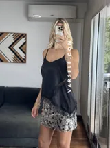 Musculosa lencera blanca con encaje, escote pico y tirantes finos. Bajo asimétrico.