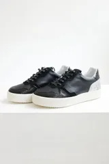 Championes urbanos de cuero color negro con cordones negros y suela blanca. Incluye un par de cordones adicionales de otro color.