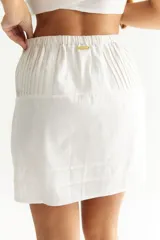 Minifalda estampada con motivos florales en tonos naranja, marrón y negro. Tiene cintura elástica y diseño plisado.