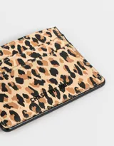 Tarjetero de cuerina con estampado animal print en tonos beige y marrón.