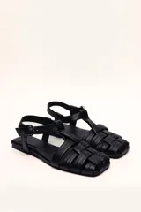 Sandalias franciscanas rojas de cuero con tiras entretejidas y hebilla lateral.