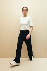Pantalón negro de punto, corte suelto, con elástico en la cintura y aberturas en el ruedo.